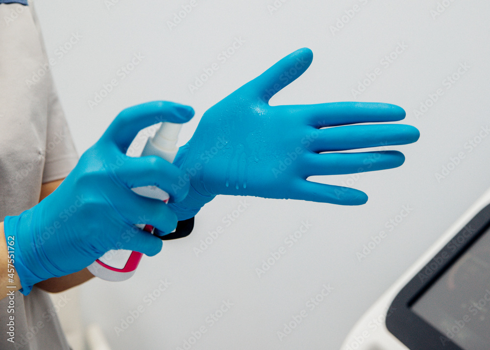 Young women's hands in medical gloves, an employee treats their hands with an antiseptic. Young women's hands in medical gloves, an employee treats their hands with an antiseptic.