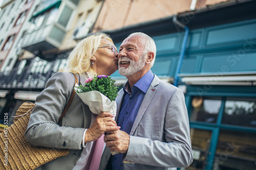 Romantic middle-aged man giving his wife flowers