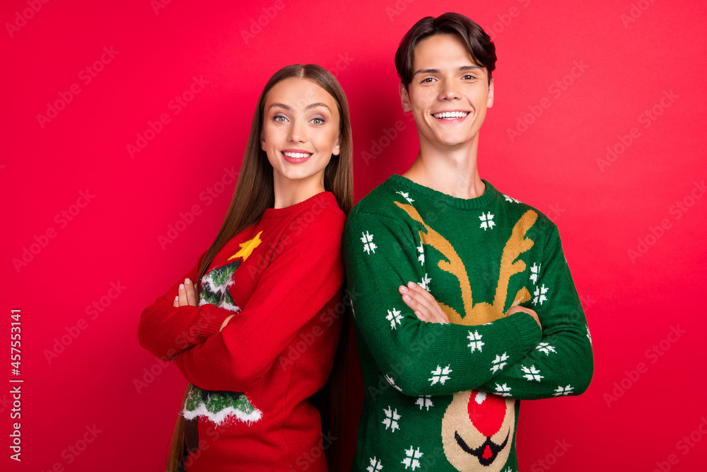 Photo of self-assured two friends folded arms look camera posing wear ugly sweater isolated red color background Photo of self-assured two friends folded arms look camera posing wear ugly sweater isolated red color background