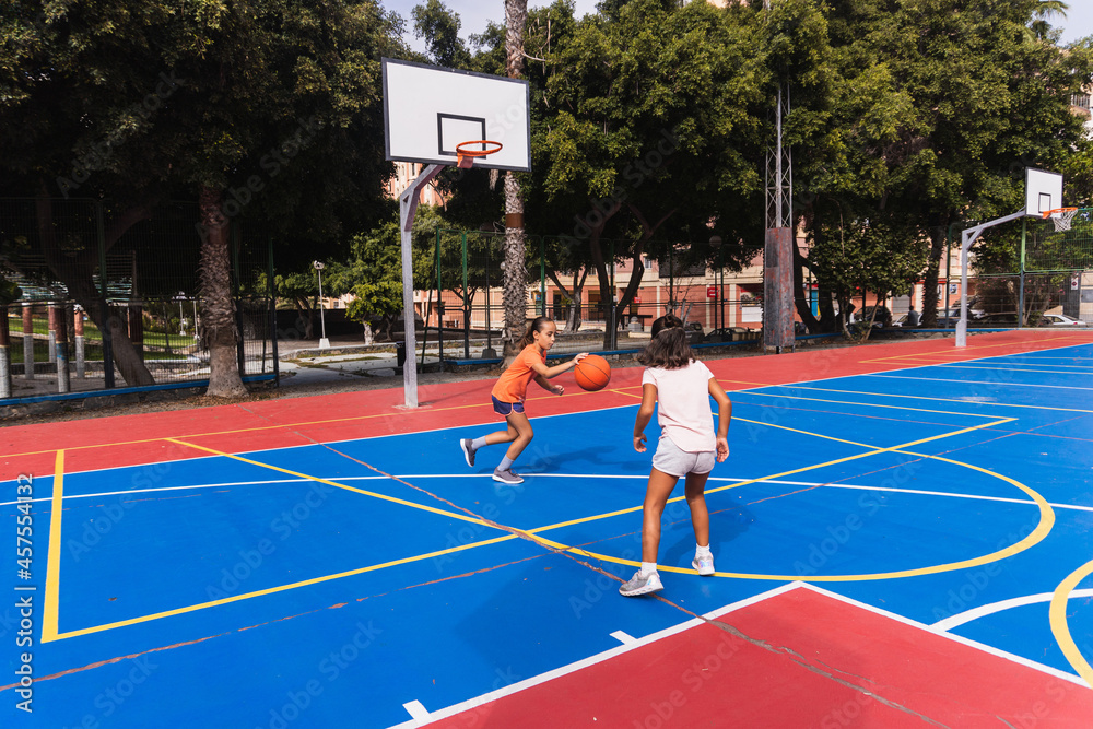 Children playing basketball on a court.