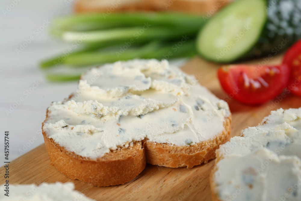 Toasted bread with cream cheese on wooden board, closeup Toasted bread with cream cheese on wooden board, closeup