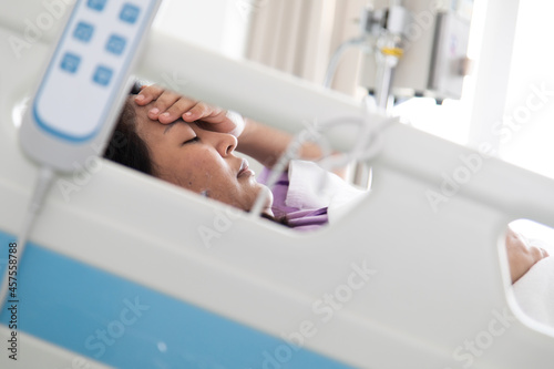 Asian fat woman patient feeling sad and depressed lying at hospital bed