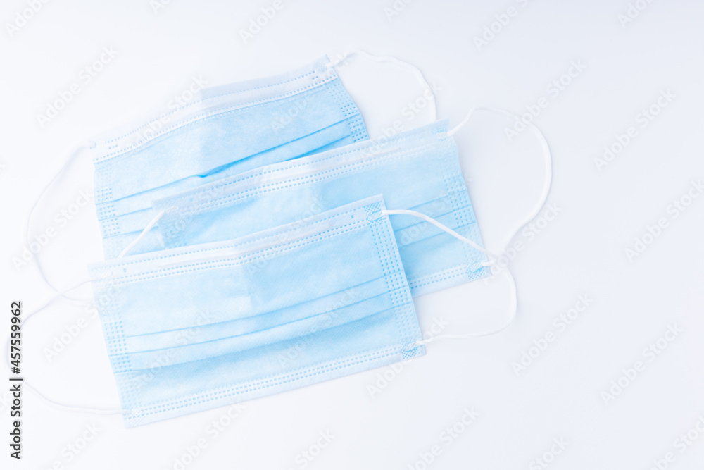 3 light blue disposable medical masks isolated on a white background. Used to prevent the coronavirus, saliva spray from people infected with Covid-19. Concept health care protection coronavirus. 3 light blue disposable medical masks isolated on a white background. Used to prevent the coronavirus, saliva spray from people infected with Covid-19. Concept health care protection coronavirus.