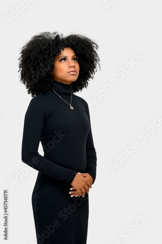  portrait of a beautiful black girl looking confident, long black dress, space for isolated text on gray background