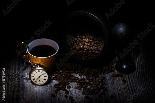 fresh coffee beans with cup of coffee and watch