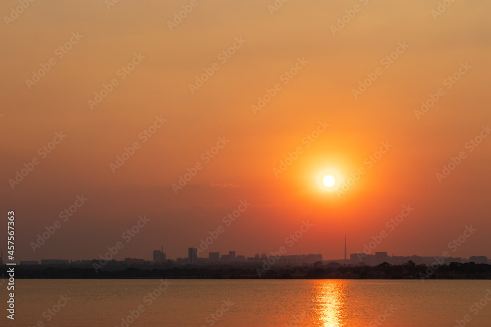Pôr do sol sobre a cidade e o lago em Brasília, Brasil.