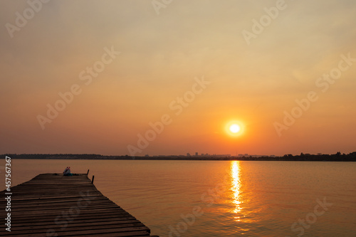 Pôr do sol com píer sobre a cidade e o lago em Brasília, Brasil. © Raulzito Moura