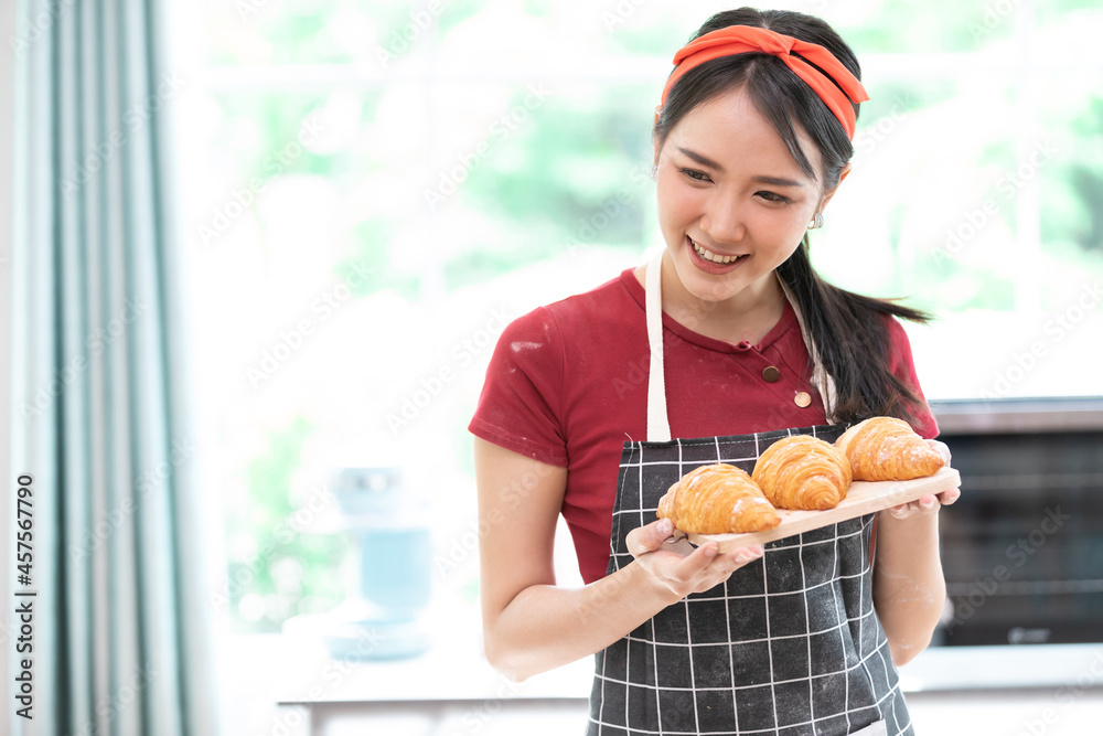 young woman housewife holding fresh croissants on the cutting board, for enjoy eating in the kitchen young woman housewife holding fresh croissants on the cutting board, for enjoy eating in the kitchen
