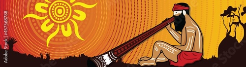 Aboriginal man playing a didgeridoo landscape background