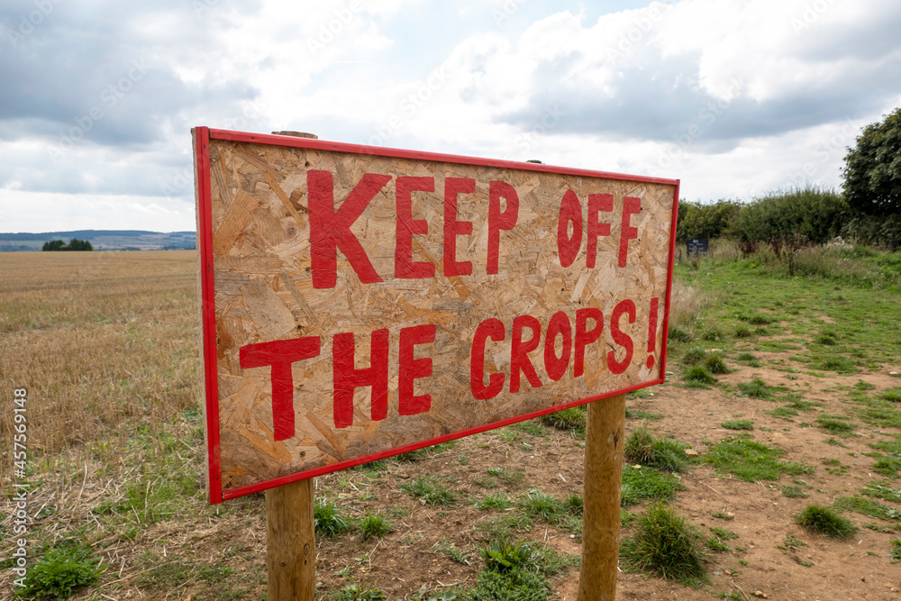 Oxfordshire, England, UK. 2021. A farmers hand painted sign in red paint saying, keep off the crops ! I a field in Cotswolds area of the UK.