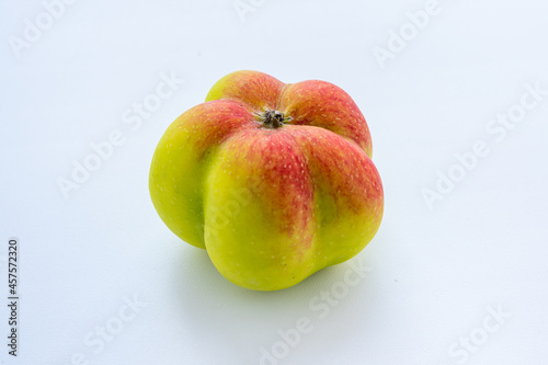 An interesting, unusual, strange apple. An ugly apple surrounded by ordinary ones. The photo symbolizes individuality, leadership, personal characteristics, self-acceptance.