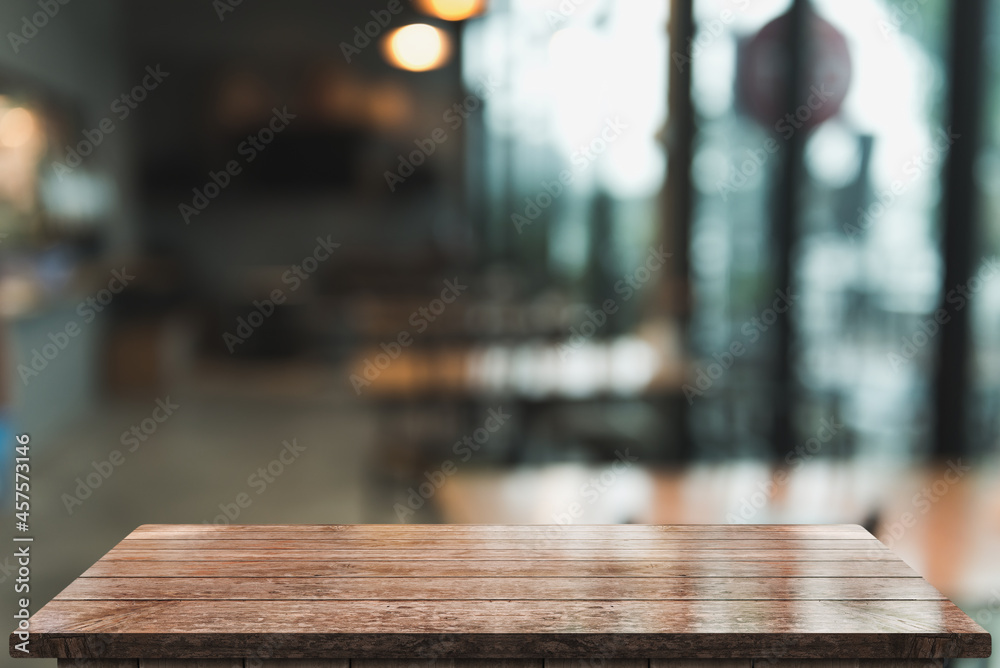 Empty wooden table top with lights bokeh on blur restaurant background.
Empty wooden table top with lights bokeh on blur restaurant background.
