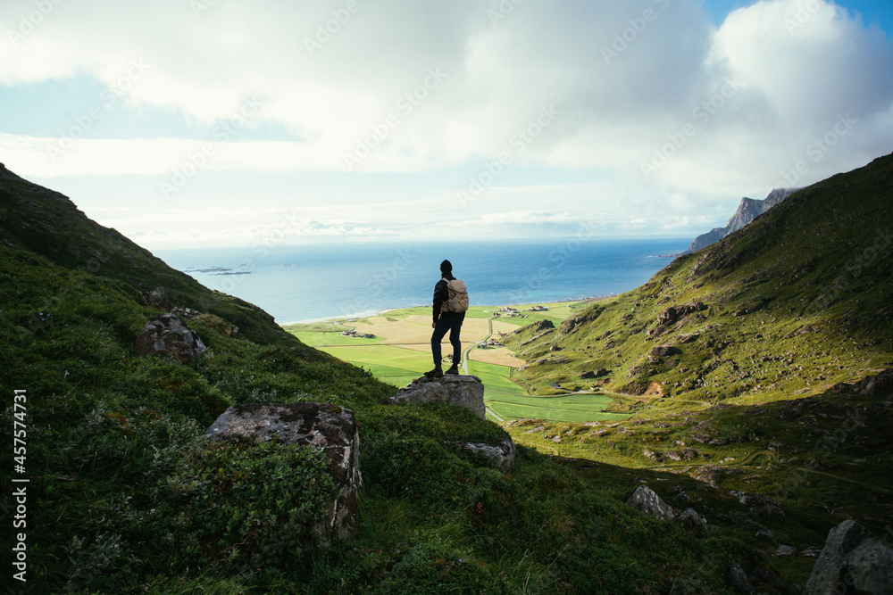 Φωτογραφία Man with hiking backpack stand on top of mountain, overlook epic views and nordic scandinavian landscape