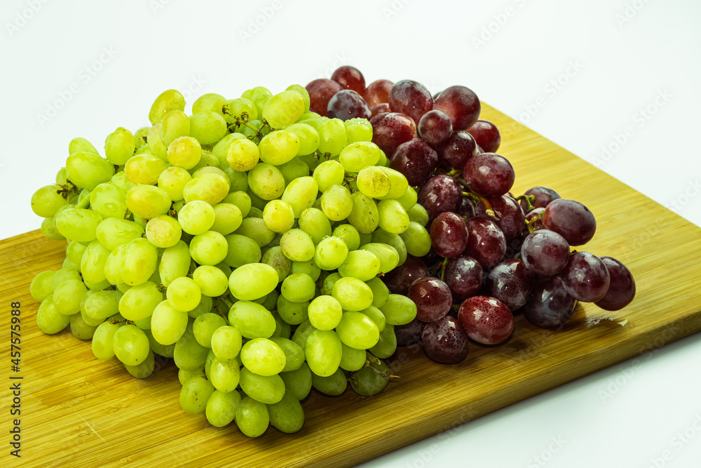 Bunch of red and green fresh grapes on wood and white bacground