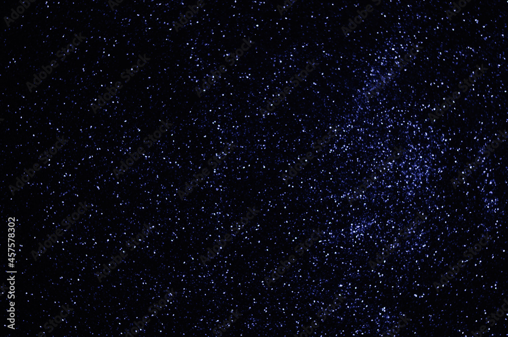 Blue stars in space, sky, defocused blue lights, shiny particles, abstract background