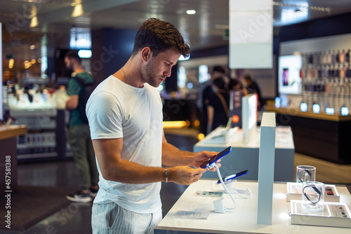 Young man buying gadget in store