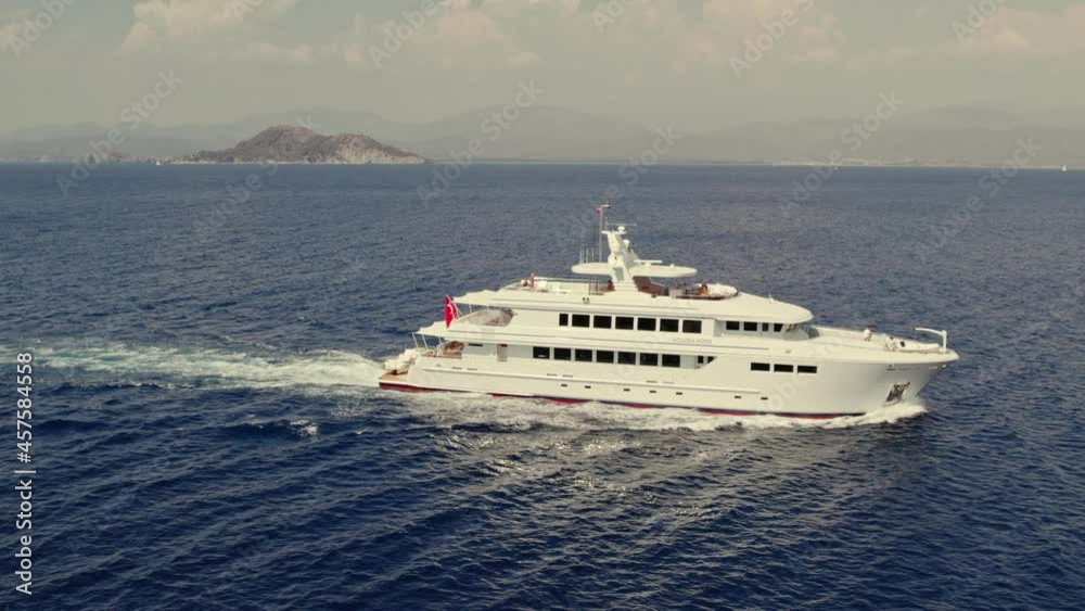 Luxury yacht cruising out at deep blue Mediterranean Sea. Aerial view of 3-deck luxury yacht cruising. Aerial drone tracking sailing Motor Yacht boat. on ocean. Fethiye, Muğla, Turkey Luxury yacht cruising out at deep blue Mediterranean Sea. Aerial view of 3-deck luxury yacht cruising. Aerial drone tracking sailing Motor Yacht boat. on ocean. Fethiye, Muğla, Turkey