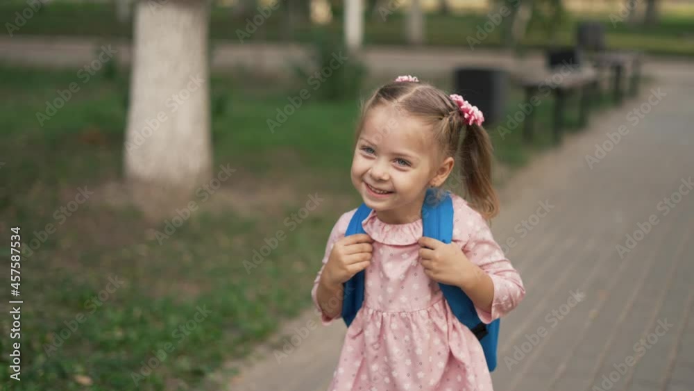Schoolgirl girl goes to school. New normal. Schoolgirl walks with backpack in park. Back to school. Social distance in park. Schoolgirl with backpack goes to class. Preschool girl. Educational school Schoolgirl girl goes to school. New normal. Schoolgirl walks with backpack in park. Back to school. Social distance in park. Schoolgirl with backpack goes to class. Preschool girl. Educational school