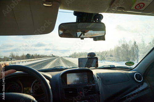 Siberia, Russia - November 28, 2020: View from of car interior from side of driver to the road and nature landscape through the windshield