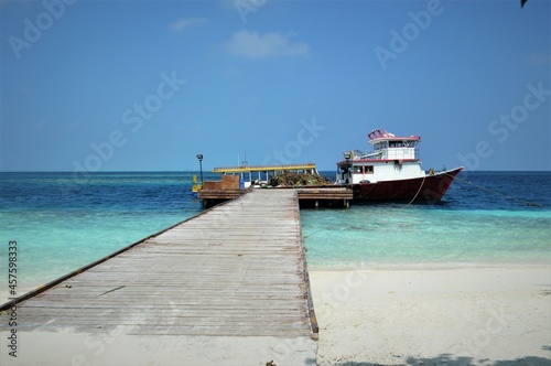 RANGALI ISLAND, MALDIVES - JANUARY 06,2018: wooden pier on the tropical island of Maldives, fishing vessel, background photo