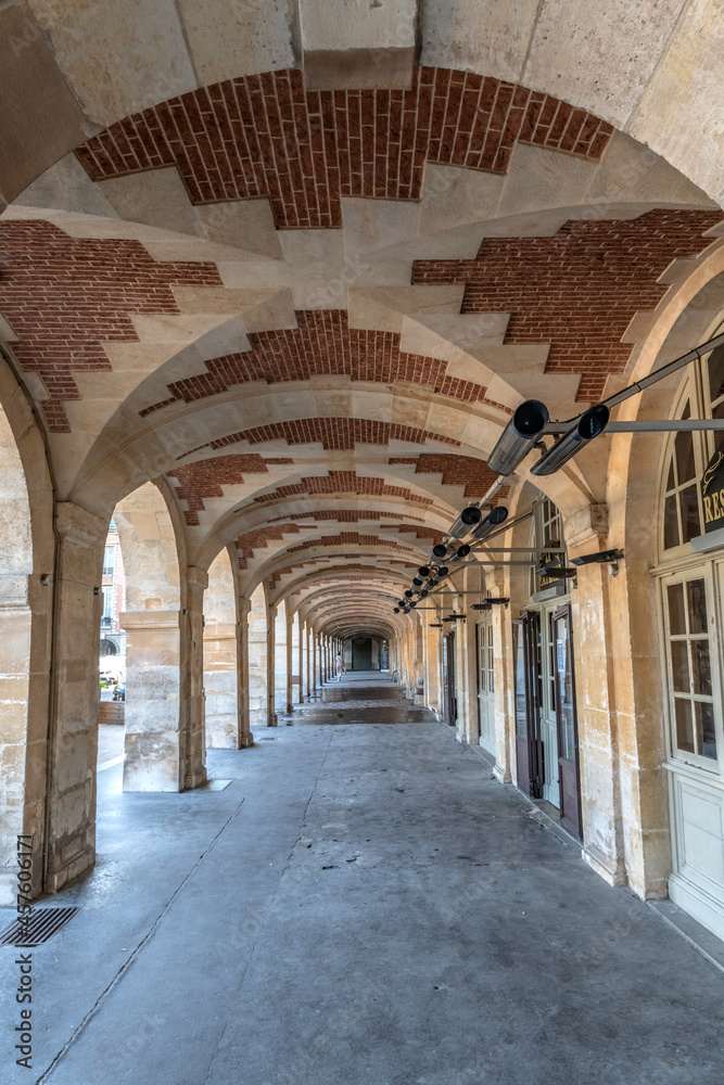 Fototapeta premium Passage sous les voûtes en brique autour de la place des Vosges dans le centre de Paris