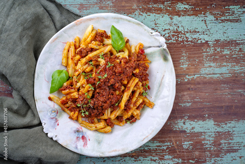 Traditional casarecce al bronzo al rag italian pasta with minced meat tomato ragu sauce served as top view on a design plate with copy space right photo