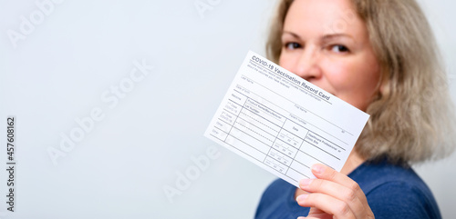 Картината върху платно Young woman showing COVID-19 Vaccination Record Card