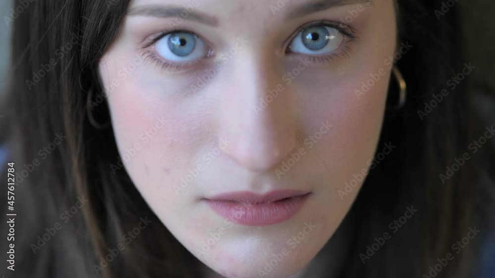 thoughts, worries . young woman looks up and stares serious at camera thoughts, worries . young woman looks up and stares serious at camera