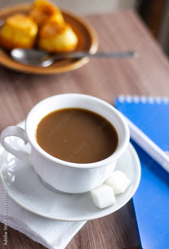 Closeup cup of coffee pen and notebook on the table office business working sugar wooden paper pad notepad spoon nobody espresso latte Closeup cup of coffee pen and notebook on the table office business working sugar wooden paper pad notepad spoon nobody espresso latte