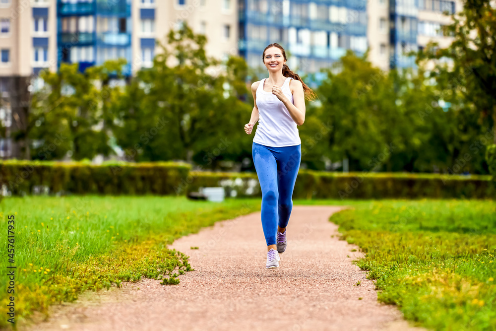 Happy woman runs in park for being healthy.