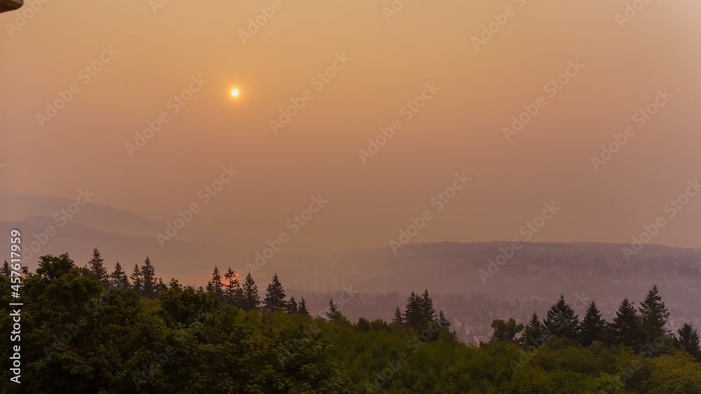 Sun rise seen over Fraser Valley, BC, seen through smoke haze from many forest fires burning in BC interior during summer of record-breaking heat and extended drought