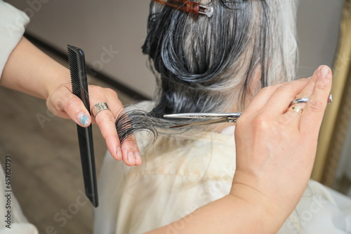 高齢者のヘアカットをする美容師（手元）
