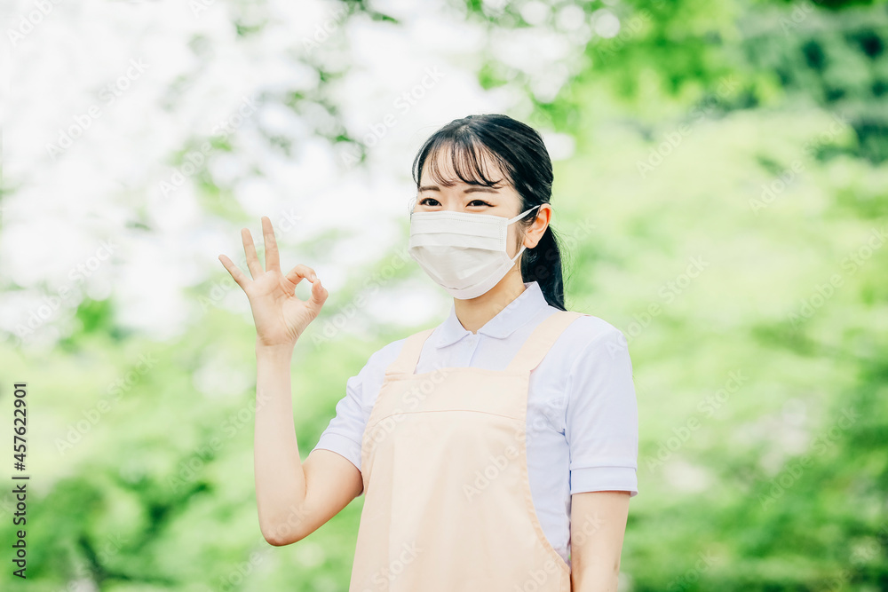 マスクをつけたエプロン姿の女性
