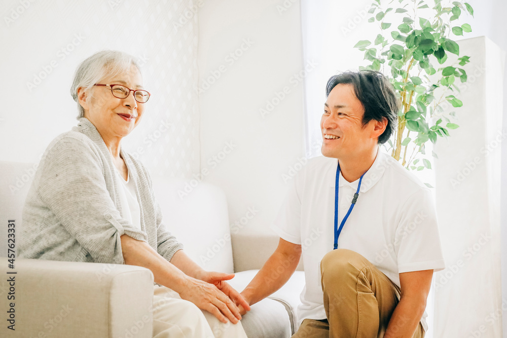 訪問介護する男性と高齢者(笑顔)
訪問介護する男性と高齢者(笑顔)