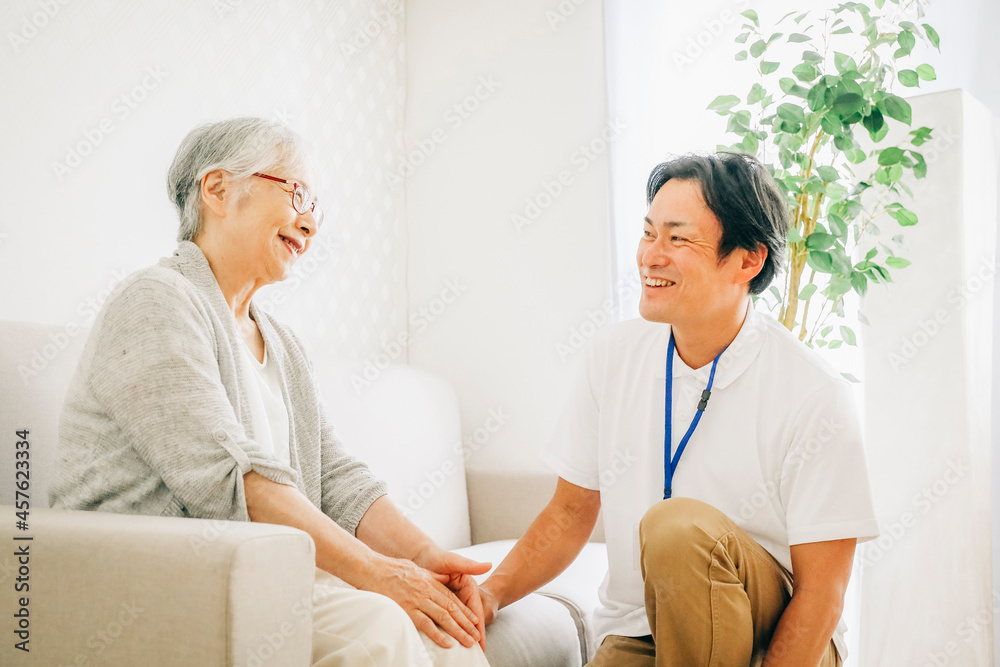 Fototapeta premium 訪問介護する男性と高齢者(笑顔)