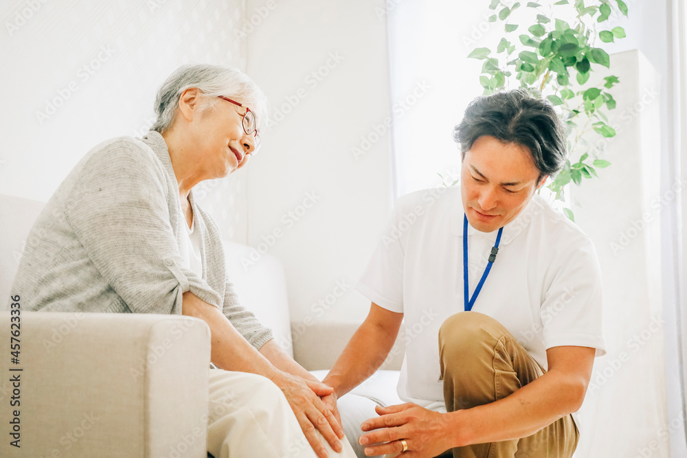 Fototapeta premium 訪問介護する男性と高齢者（膝） 