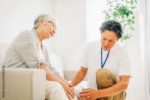 訪問介護する男性と高齢者（膝）  © buritora