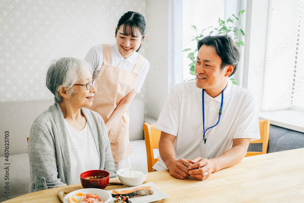 食事する高齢者と男女のスタッフ
食事する高齢者と男女のスタッフ