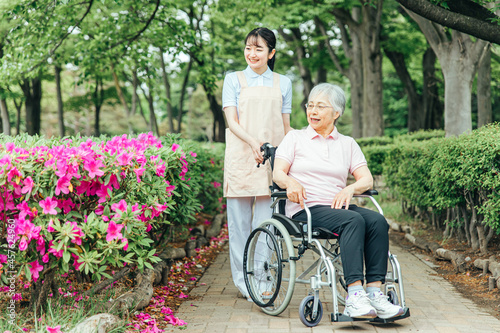 車椅子に乗った高齢者女性と女性スタッフ 