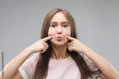 Portrait of beautiful young woman happiness standing finger touch cheek on gray background