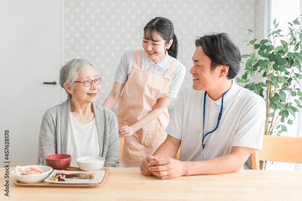 食事する高齢者と男女のスタッフ
食事する高齢者と男女のスタッフ