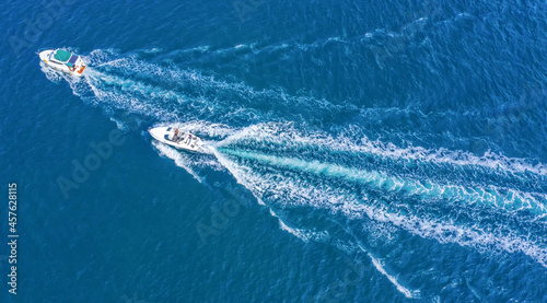 Two boats floating on the sea at high speed drone view. © maykal