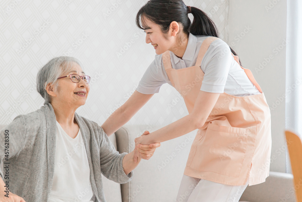 訪問介護する女性と高齢者(笑顔)
訪問介護する女性と高齢者(笑顔)