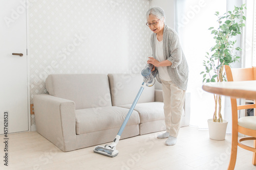 部屋を掃除する高齢者女性（笑顔） 