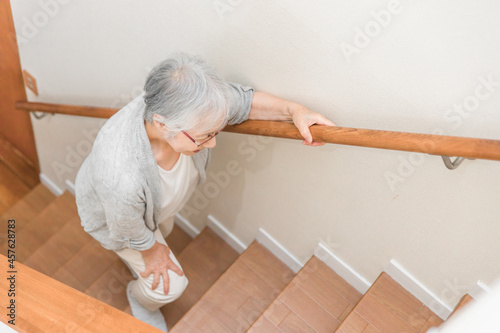 Fotobehang 階段を登る高齢者女性