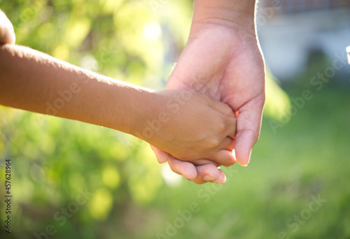 Close up of mother hand holding her child hand. © maew