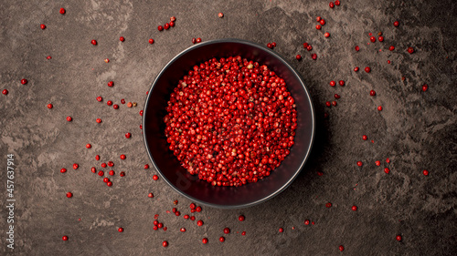 TOP VIEW: Dish with pink pepper seeds on a table