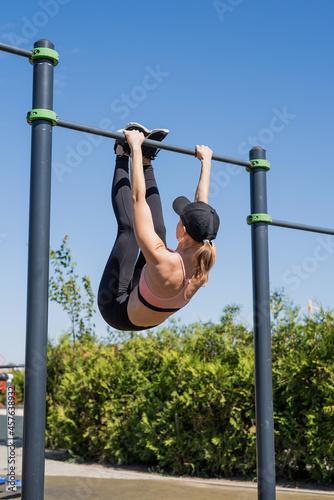 Sportive woman working out on the sports ground in sunny summer day
