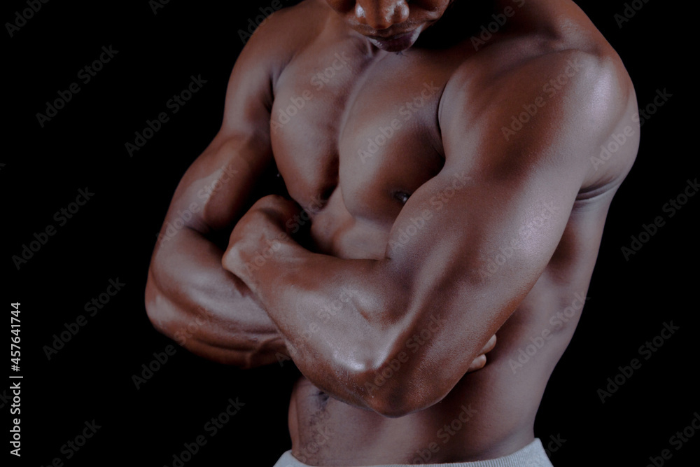 Muscled male model showing his muscles. on a black background Muscled male model showing his muscles. on a black background