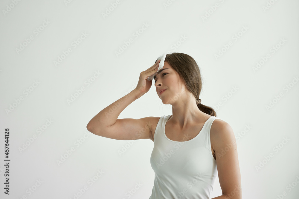 woman in white t-shirt wipes her face with a handkerchief fever health problems cold woman in white t-shirt wipes her face with a handkerchief fever health problems cold